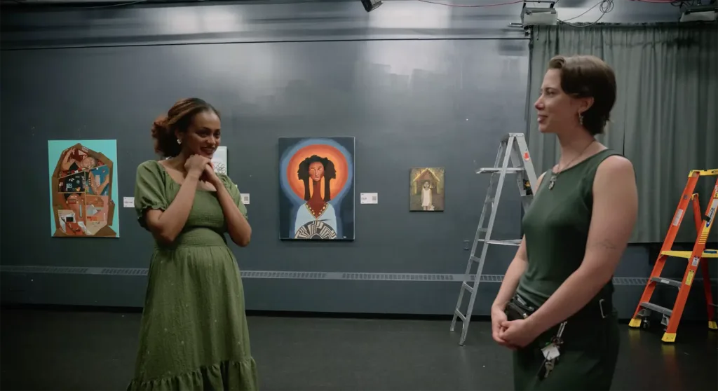 Two women stand in an art gallery